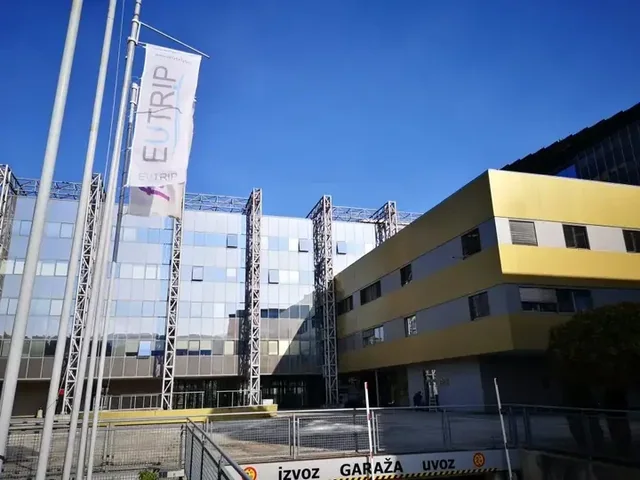 Zastava EUTRIP pred sodobnim poslovnim objektom